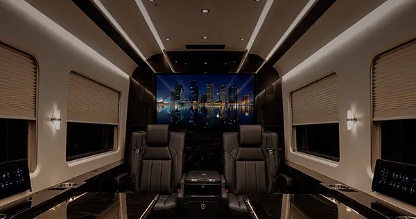 Inside the Jet Sprinter: two leather captain's chairs facing a screen